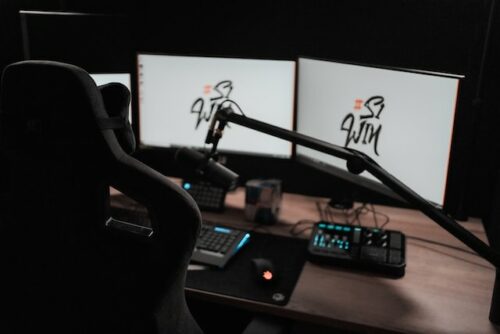Ein Streaming-Setup mit einem Gaming-Stuhl, einem Mikrofon und mehreren Bildschirmen