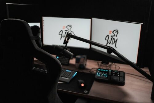 streaming Ein Streaming-Setup mit einem Gaming-Stuhl, einem Mikrofon und mehreren Bildschirmen